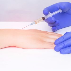 Patient receiving corticosteroid injection in hand for pain.